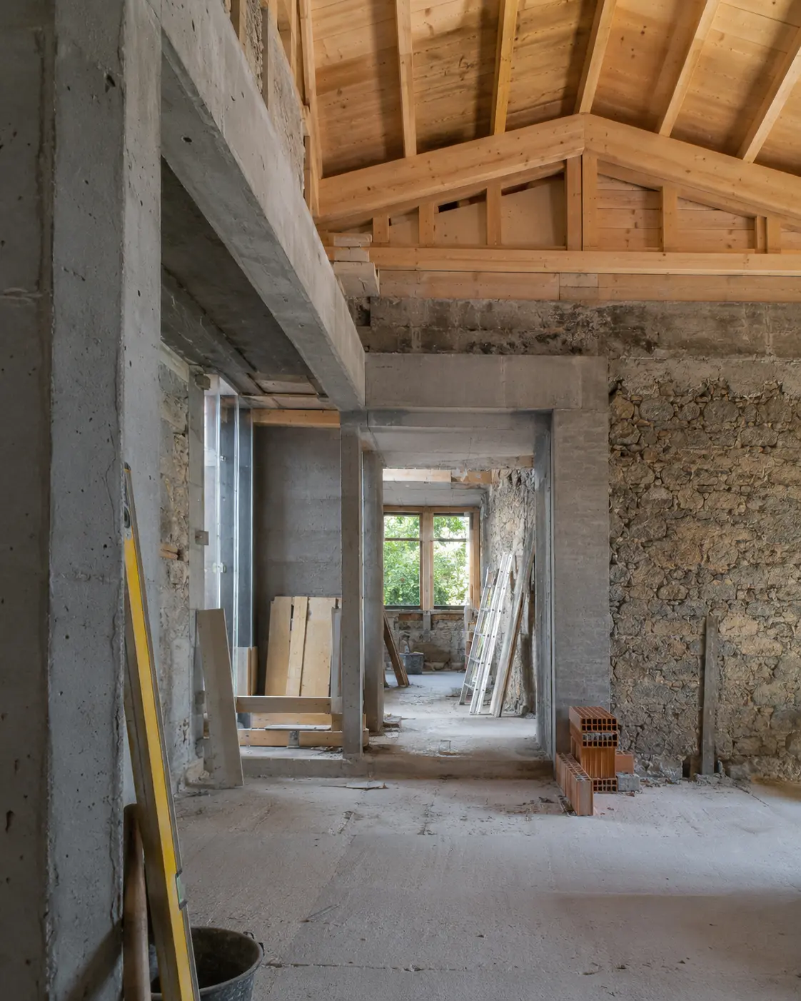 Intérieur d’un bâtiment avec maçonnerie et charpente apparentes